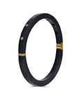 Black bracelet with gold accents on a white background
