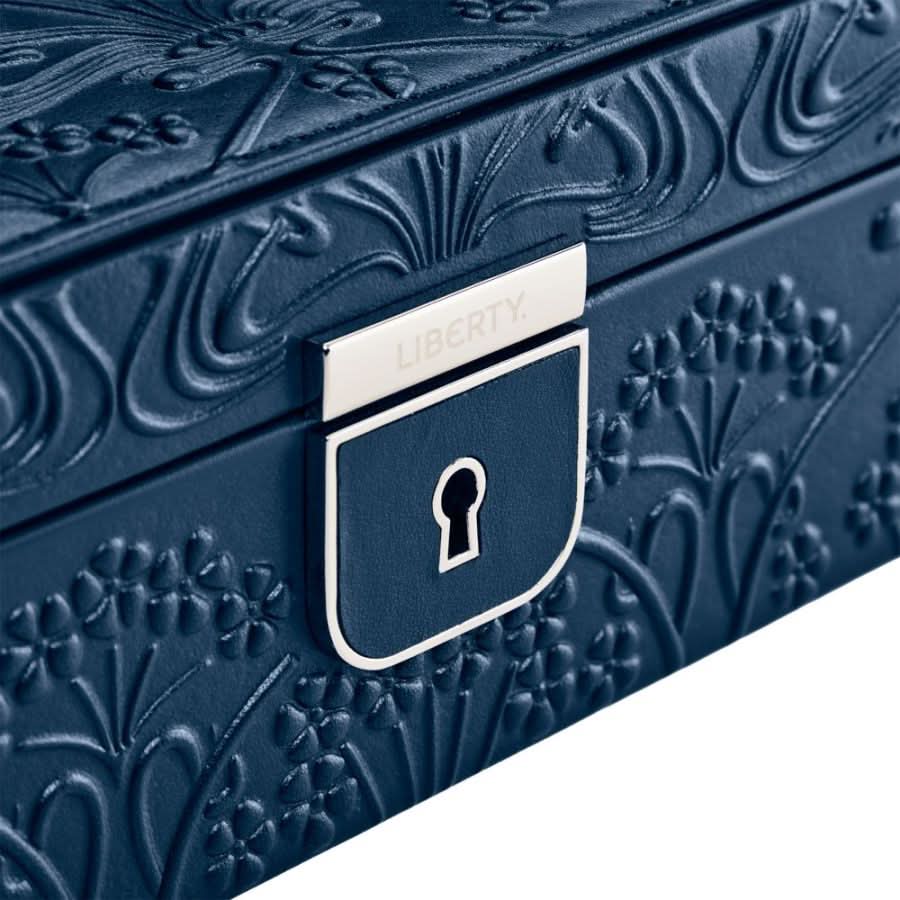 Blue jewelry box with floral embossing and a visible brand logo. close up
