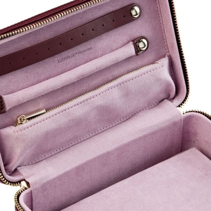 Open pink handbag with gold zippers on a white background