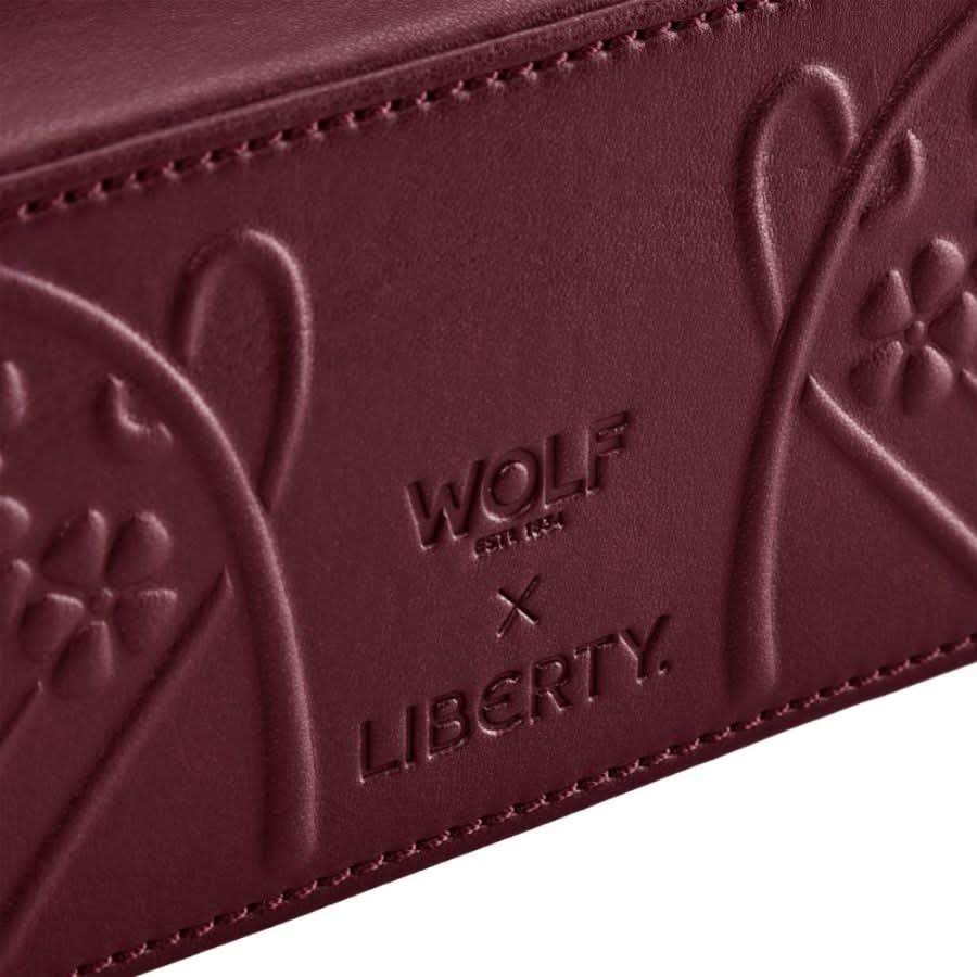 Close-up of a maroon leather product with 'Wolf & X' and 'Liberty' branding.