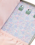 Close-up of a pink bag with floral lining and green buttons.