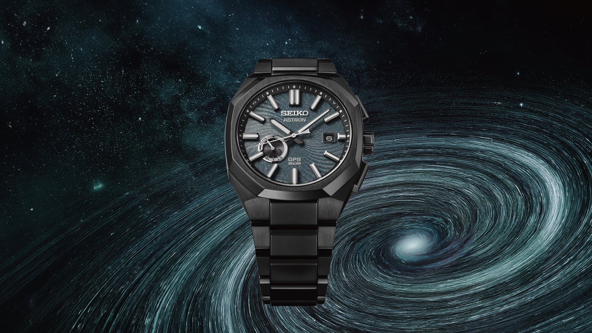 Black titanium Seiko Astron with blue textured dial on a space swirled background