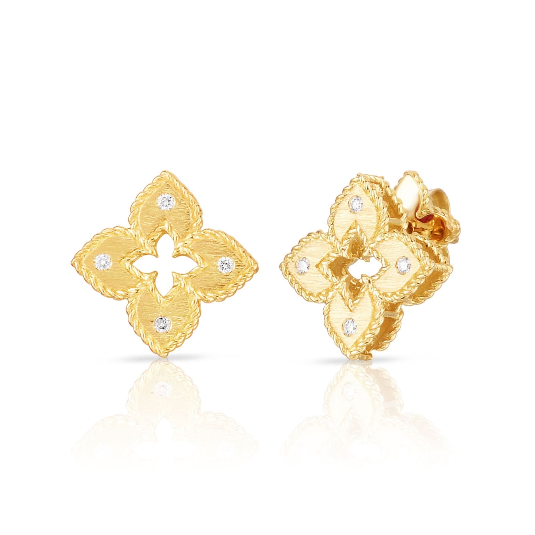 A detailed front view of the Roberto Coin Venetian Princess diamond stud earrings in 18k yellow gold (Reference 7772985AYERX), showcasing the petite open four-petal flower motif finished with a matte satin-brushed surface and accented by small shimmering diamond tips, shown as a pair against a clean white background.