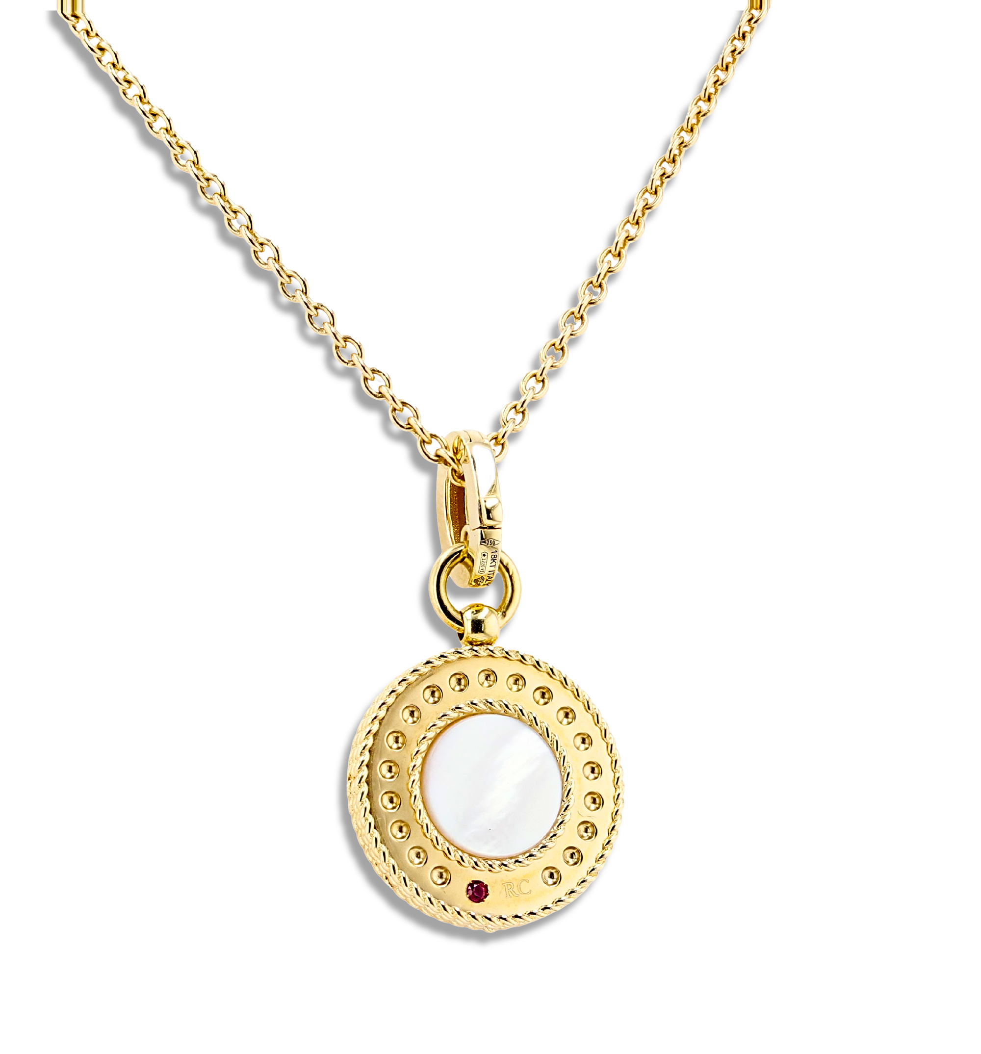 A gold pendant necklace featuring a circular disc charm with a white mother-of-pearl center, a small red gemstone accent, and a beaded outer border, suspended on a gold chain against a white background.