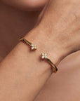 gold bracelet with flowers on wrist close up