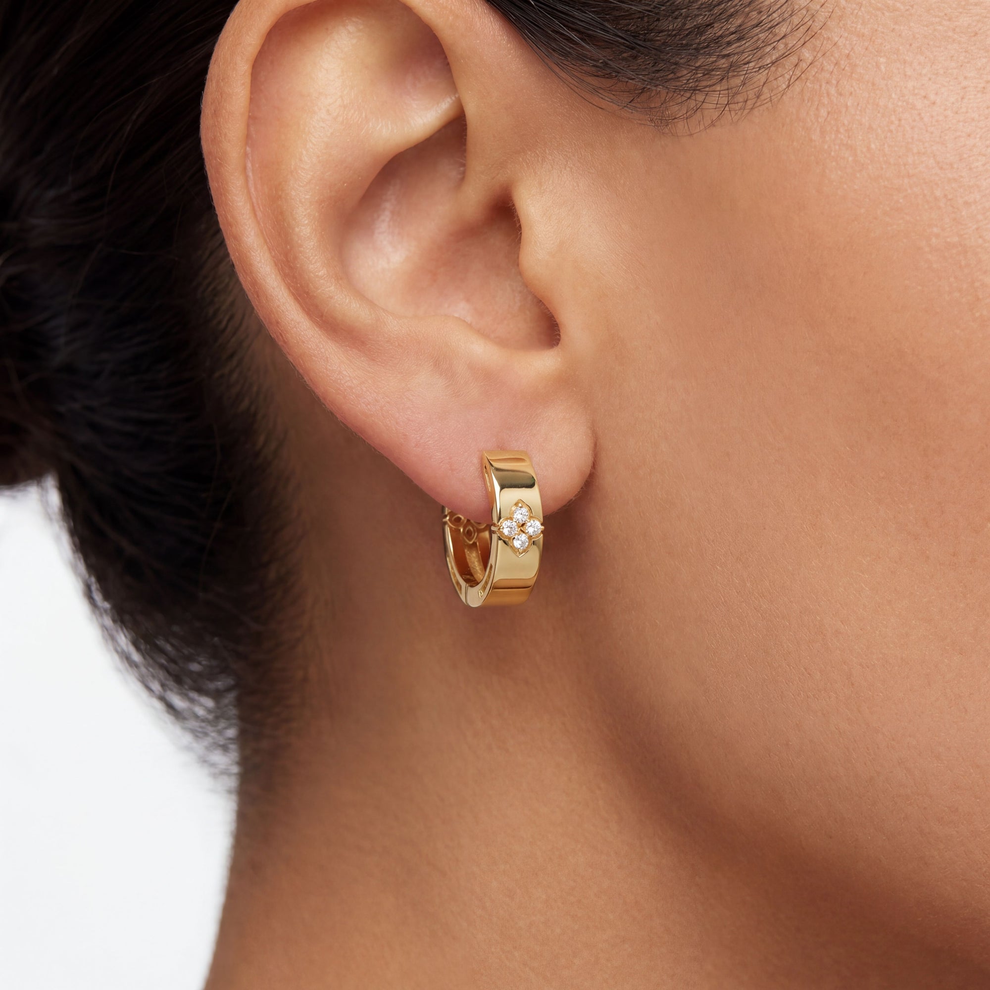 gold hoop with diamonds on a close up ear 