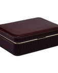 a closed maroon leather jewelry box with gold trim on a white background