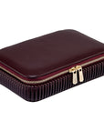 maroon leather jewelry box with gold zipper angled on a white background