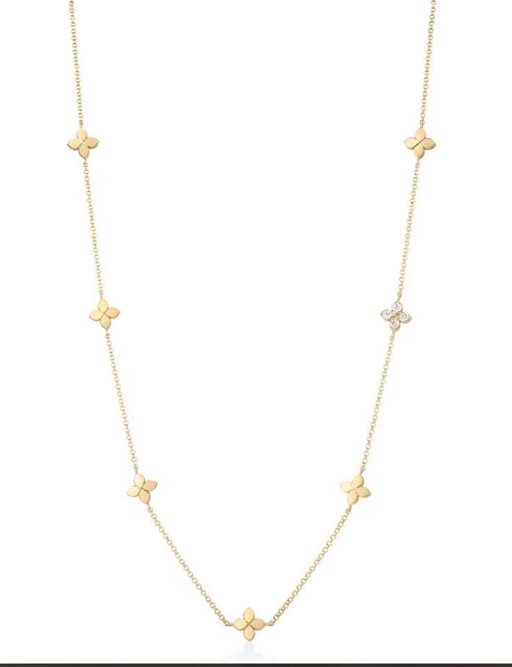 Gold necklace with flower shaped stations on a white background
