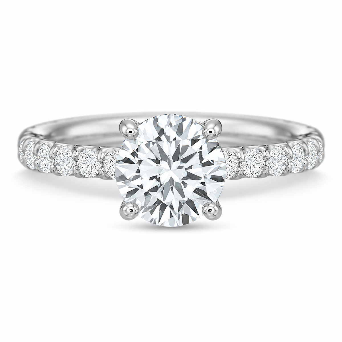 A classic solitaire engagement ring featuring a round brilliant-cut center diamond in a four-prong setting, with a polished white gold or platinum band adorned with a row of smaller round diamonds on either side, set against a seamless white background.