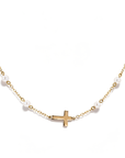 A delicate gold chain necklace featuring small white pearl beads spaced along the chain and a small gold cross pendant at the center, shown against a plain white background.