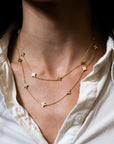 layered gold necklace on neck with white collar shirt