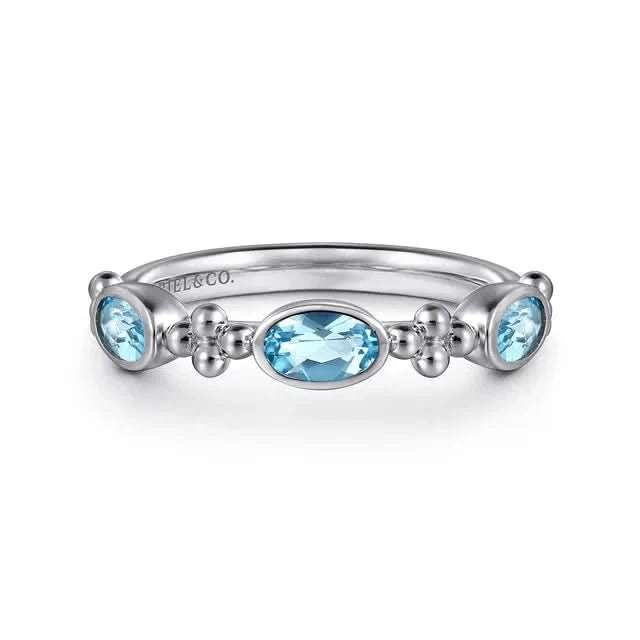 Silver ring with blue gemstones on a white background