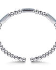 A silver-toned open cuff bracelet featuring a row of small round beads and polished rectangular links, with two links accented by light blue stones, shown on a white background.