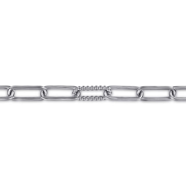 A close-up of a silver-toned chain link bracelet featuring a central textured beaded connector link, shown against a plain white background.