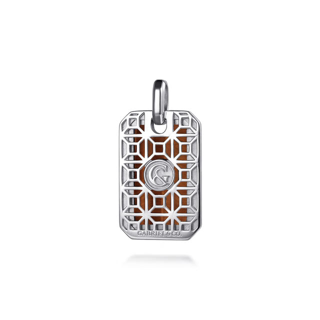 A rectangular silver pendant charm with a geometric filigree cutout pattern and a central interlocking G&amp; logo, set against a warm brown background. The brand name 'Gabriel &amp; co' is subtly printed at the bottom edge of the charm.