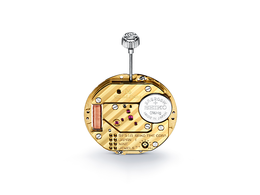 Gold tone  watch mechanism with Grand Seiko branding on a white background