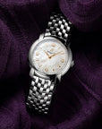 Silver Breitling watch on a textured purple fabric background