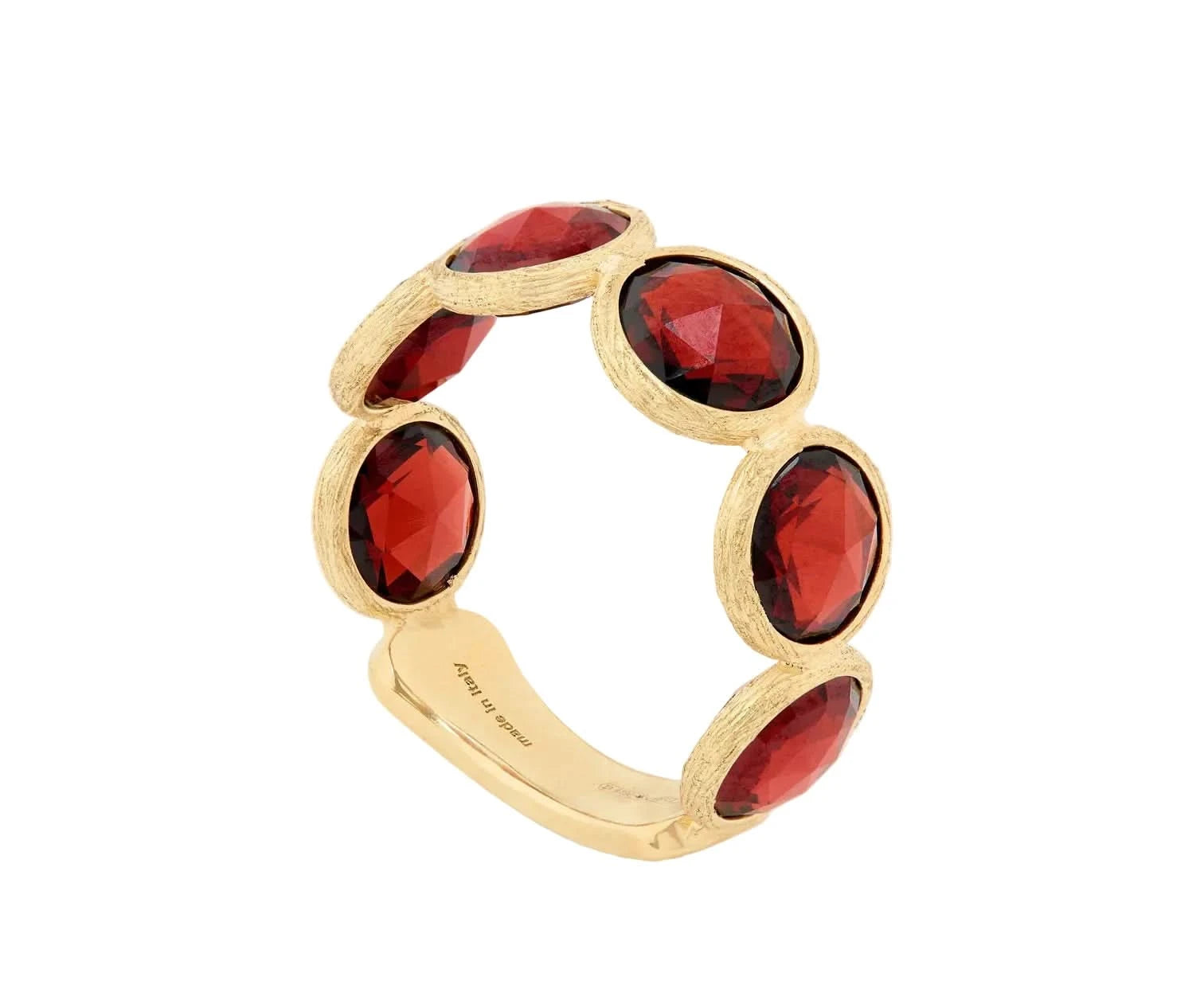 A gold band ring featuring five rose-cut deep red gemstones set in a textured bezel setting, photographed on a clean off-white background.