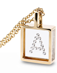 A gold square pendant necklace with a clear front panel set with diamonds  in a "A"  arrangement, hanging from a gold chain against a white background.