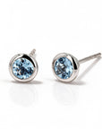 Pair of blue gemstone earrings with white gold bezels on a white background