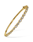 Gold bracelet with diamond accents on a white background angled