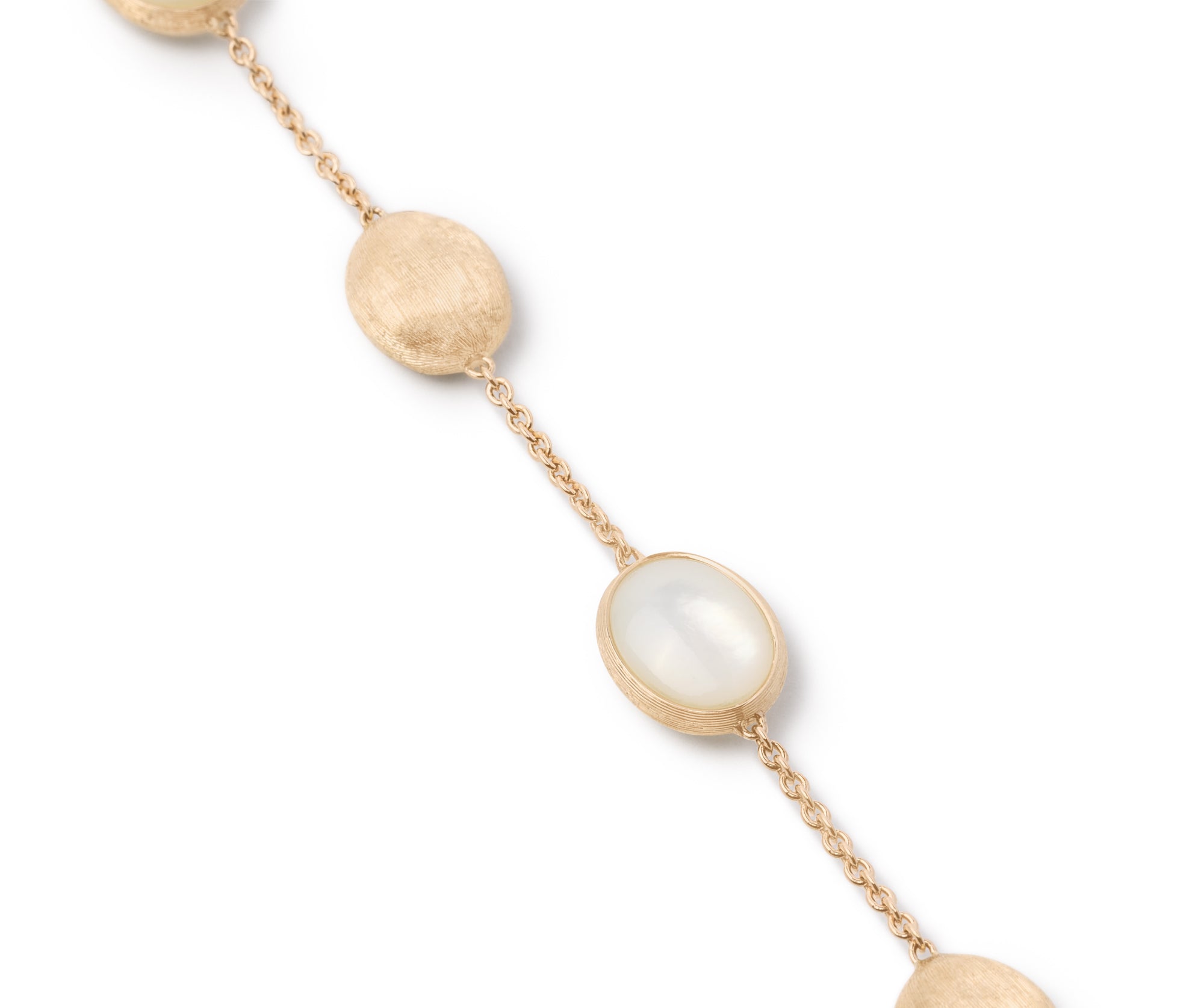Gold bracelet with mother of pearl beads on a white background close up