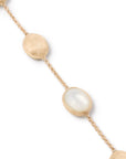 Gold bracelet with mother of pearl beads on a white background close up