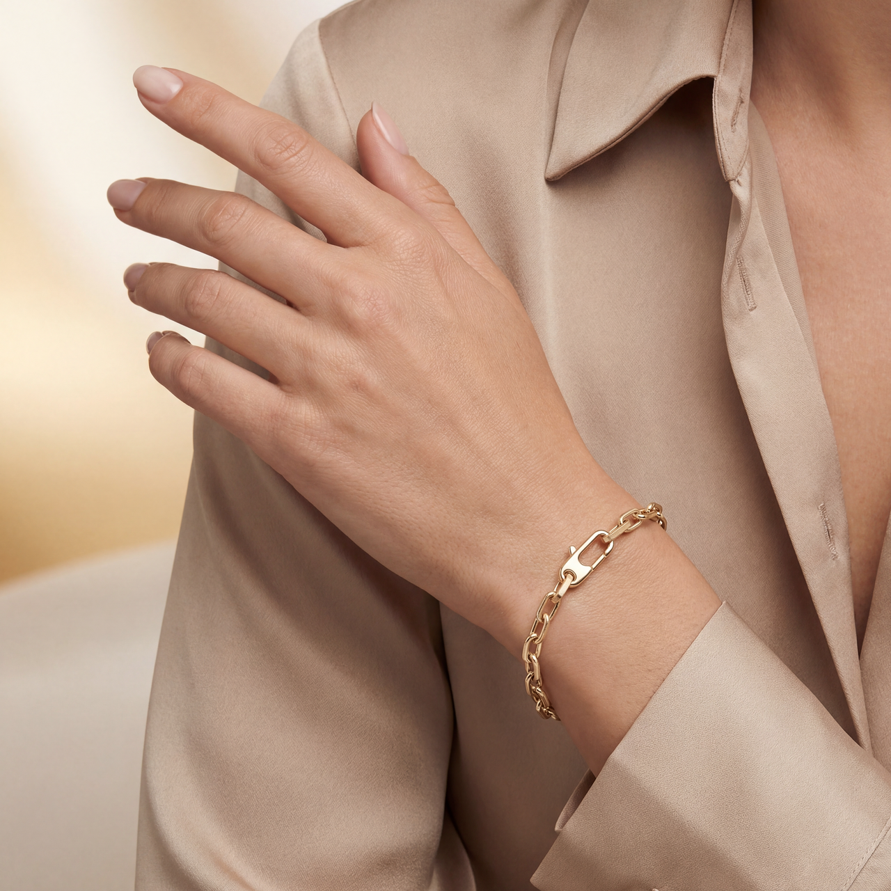 Gold bracelet on a hand with a neutral background