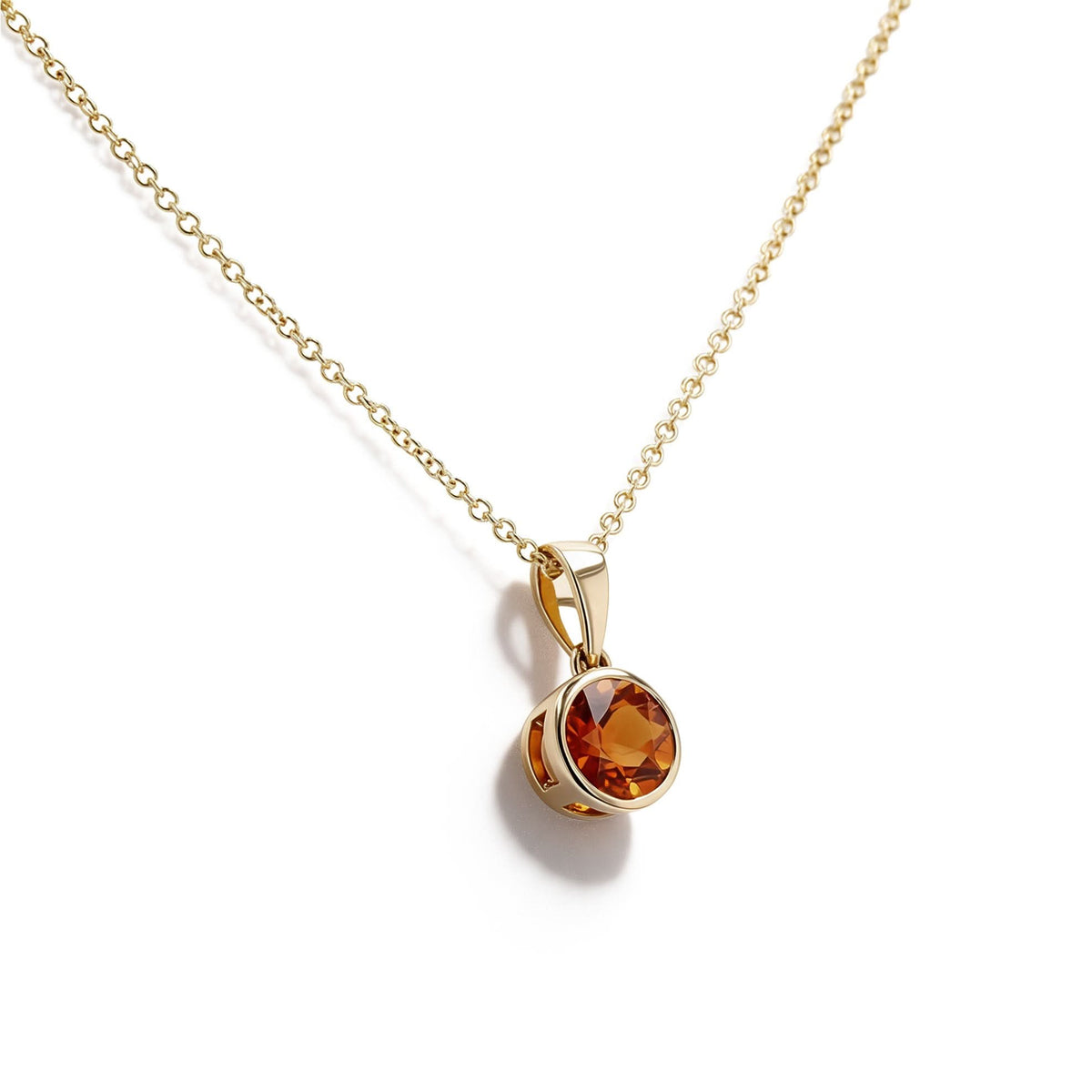 A gold chain necklace with a round bezel-set citrine gemstone pendant, displayed on a clean white background.