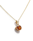 A gold chain necklace with a round bezel-set citrine gemstone pendant, displayed on a clean white background.