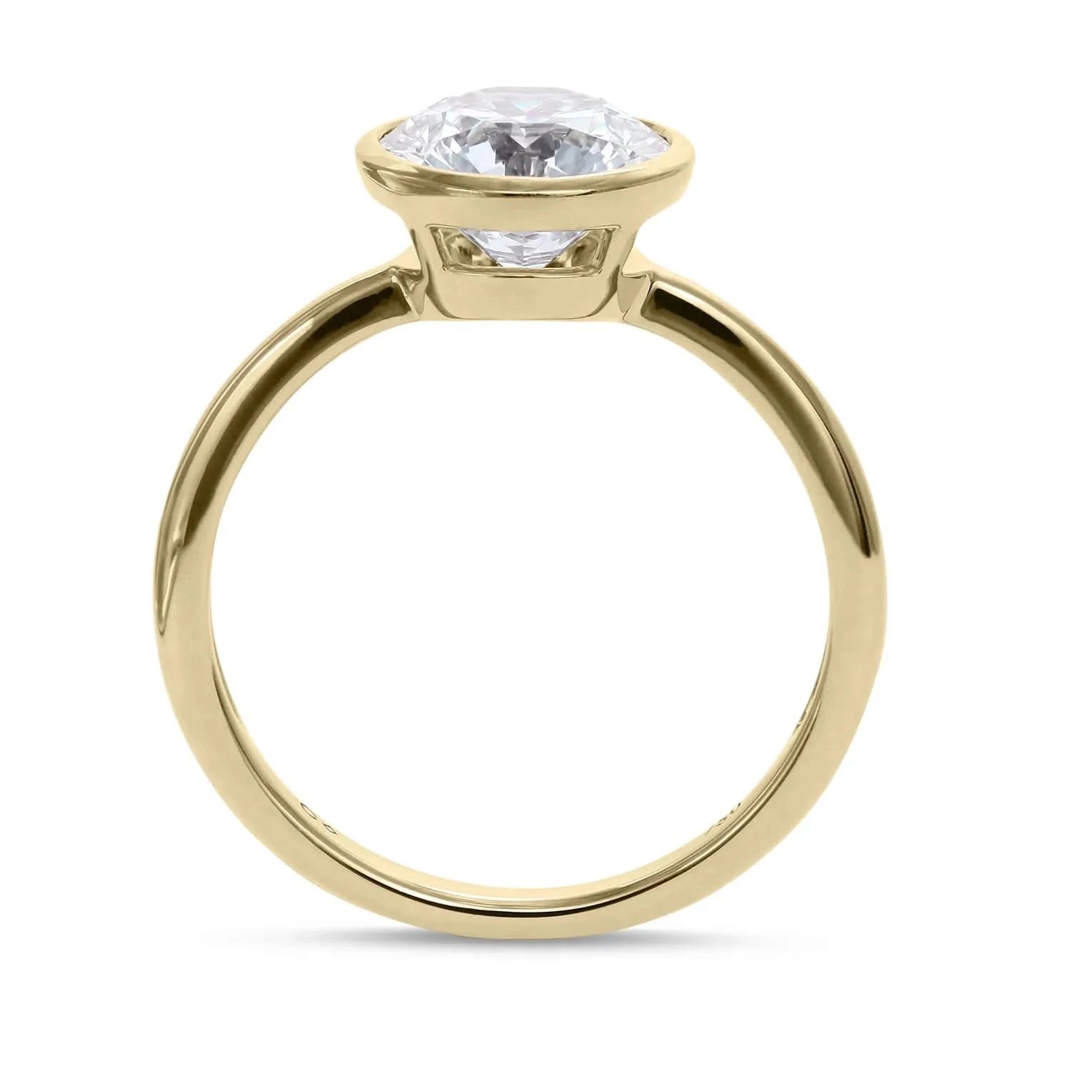 Side shot of a yellow gold solitaire engagement ring with a bezel set brilliant round diamond from Clarity Diamonds