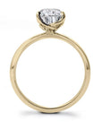 Gold ring with a lab grown pear shape diamond on a white background- side view