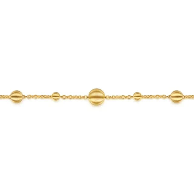 Gold bracelet with spherical beads on a white background
