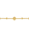 Gold bracelet with spherical beads on a white background