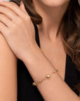 Gold bead bracelet on a person's wrist with a neutral background