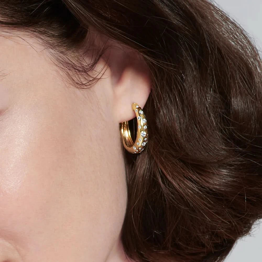 person wearing yellow gold hoop with embedded stones