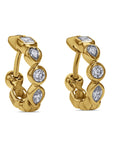 Gold hoop earrings with diamond stones on a white background