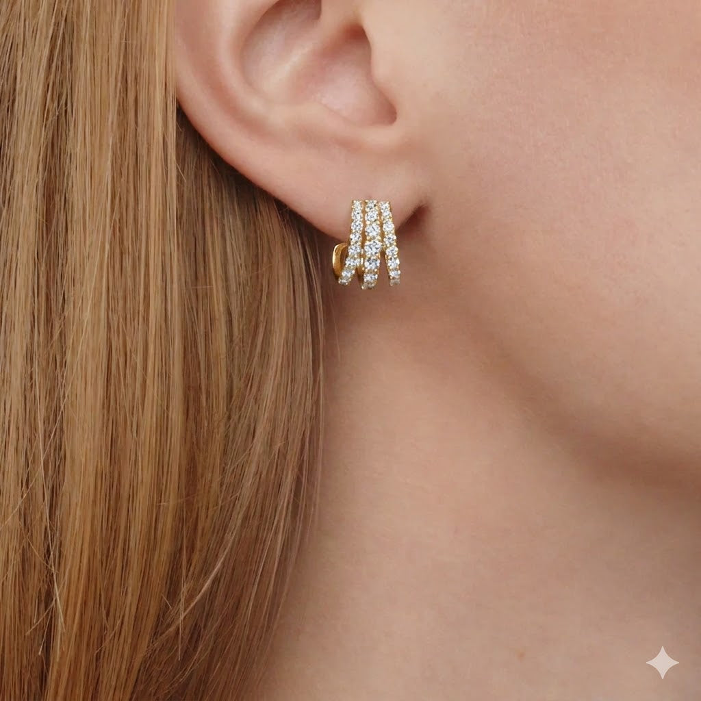 Close-up of an ear wearing a gold hoop earring with diamonds