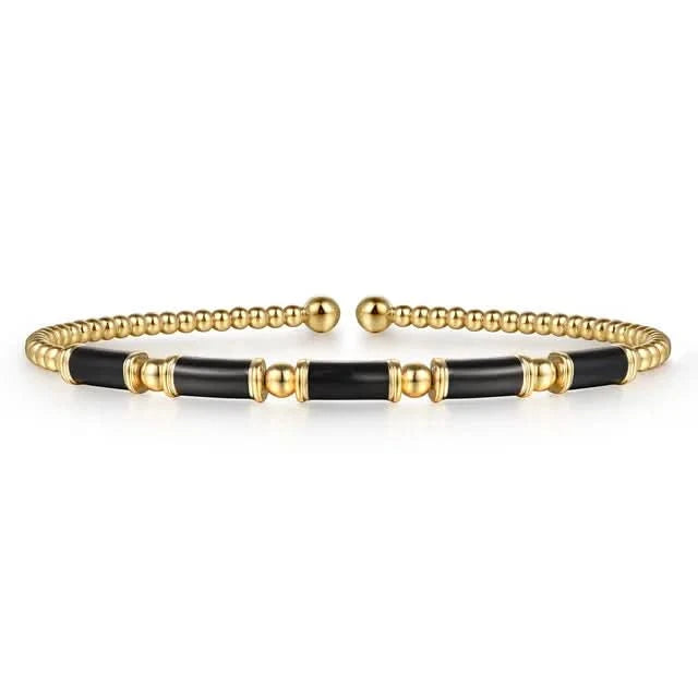 Gold and black enamel bracelet on a white background