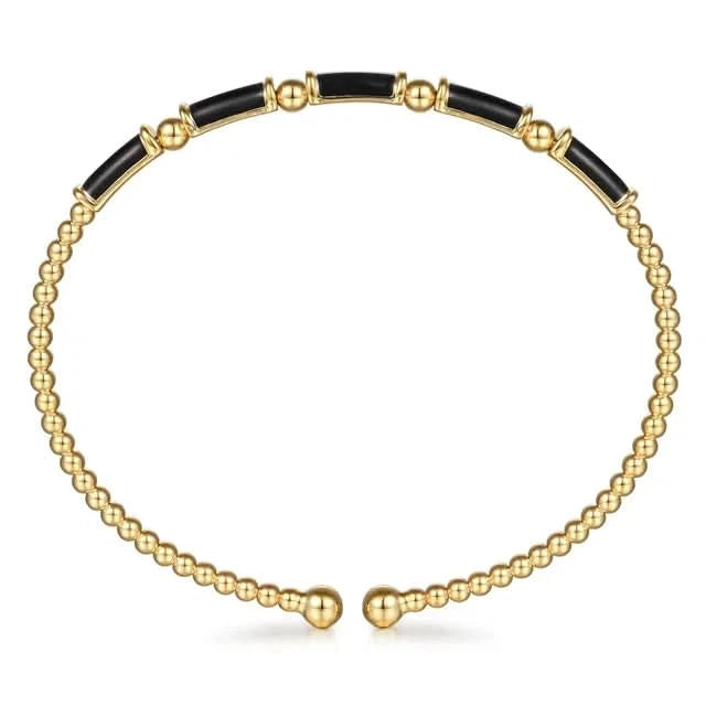 Gold and black beaded necklace on a white background side view
