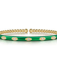 Gold and green bracelet with eye designs on a white background