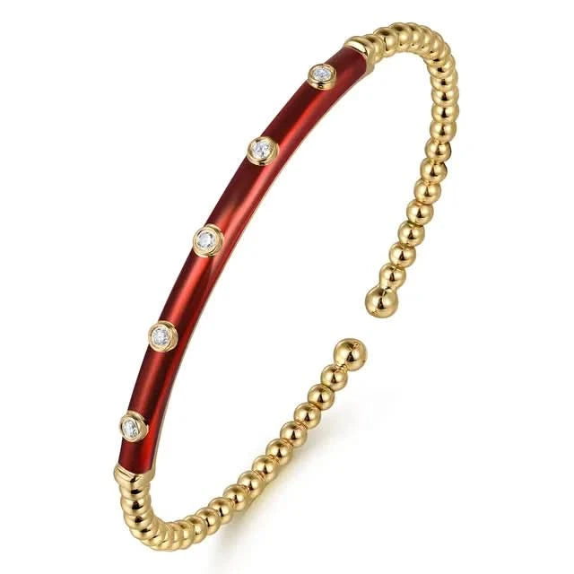 Gold and red bracelet with diamond accents on a white background angled