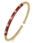 Gold and red bracelet with diamond accents on a white background angled