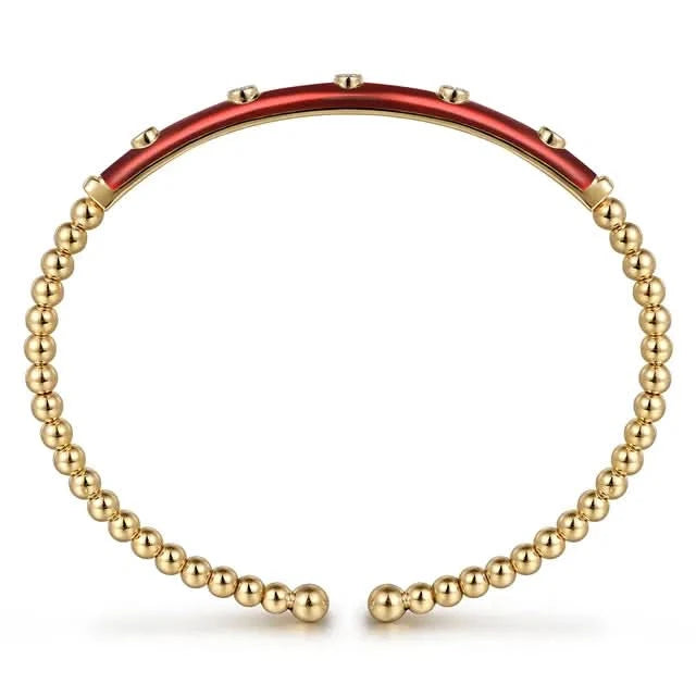 Gold beaded bracelet with a red enamel bar on a white background side view