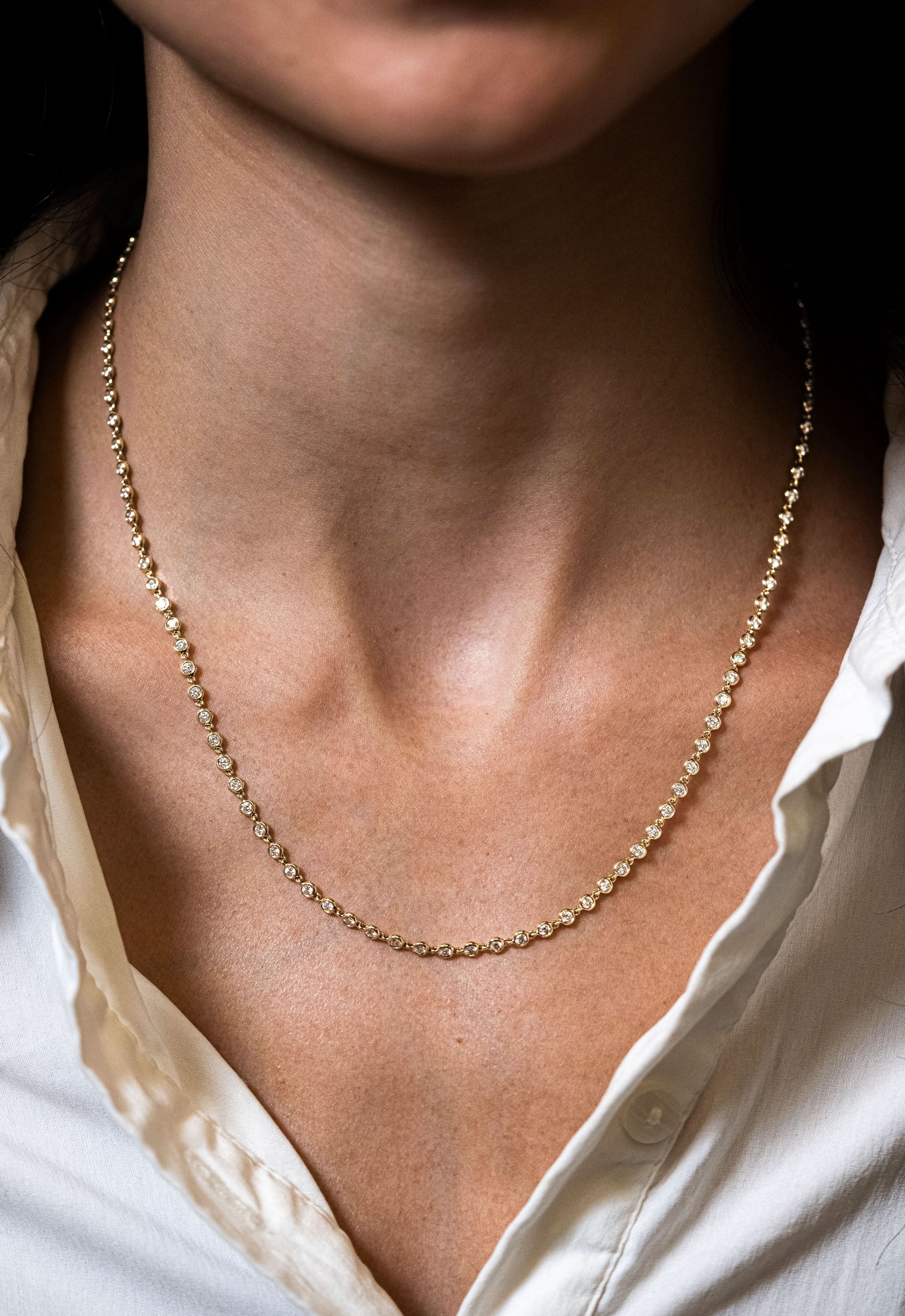 Gold Diamond necklace close up on modeled neck 