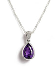 A white gold teardrop pendant necklace featuring a faceted purple gemstone, suspended from a delicate cable chain on a white background.
