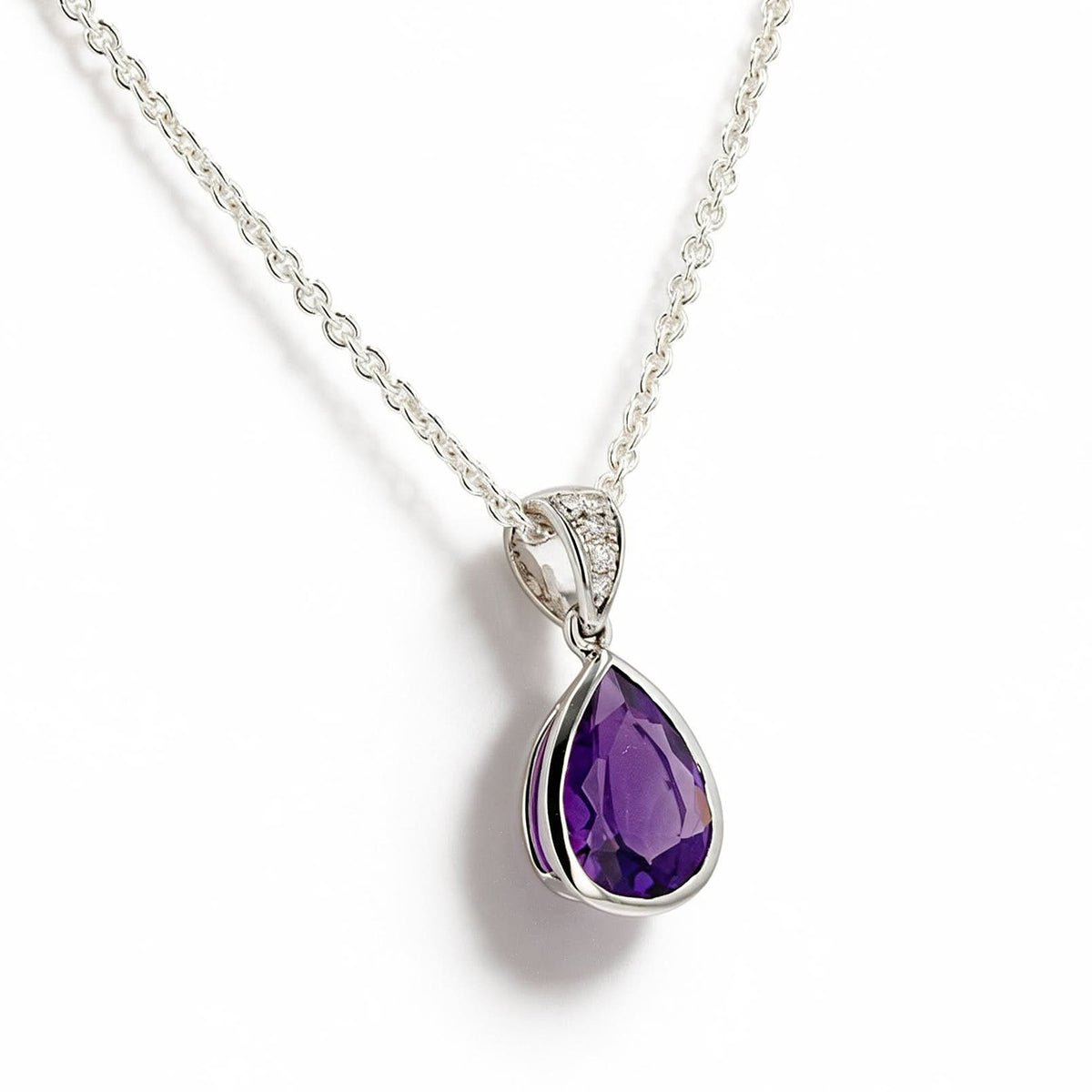 A white gold teardrop pendant necklace featuring a faceted purple gemstone, displayed slightly angled on a clean white background.