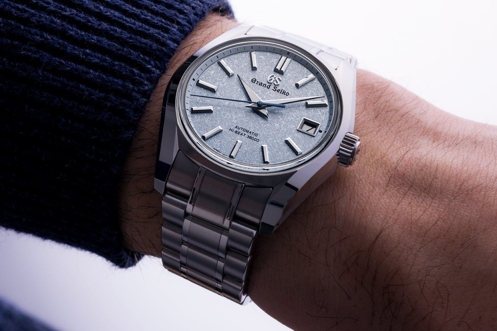 Silver wristwatch with a detailed face on a person's wrist