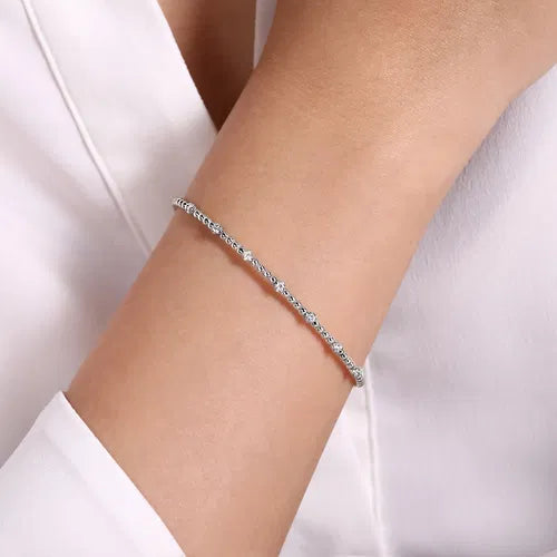 white  bracelet on a person's wrist with a white background